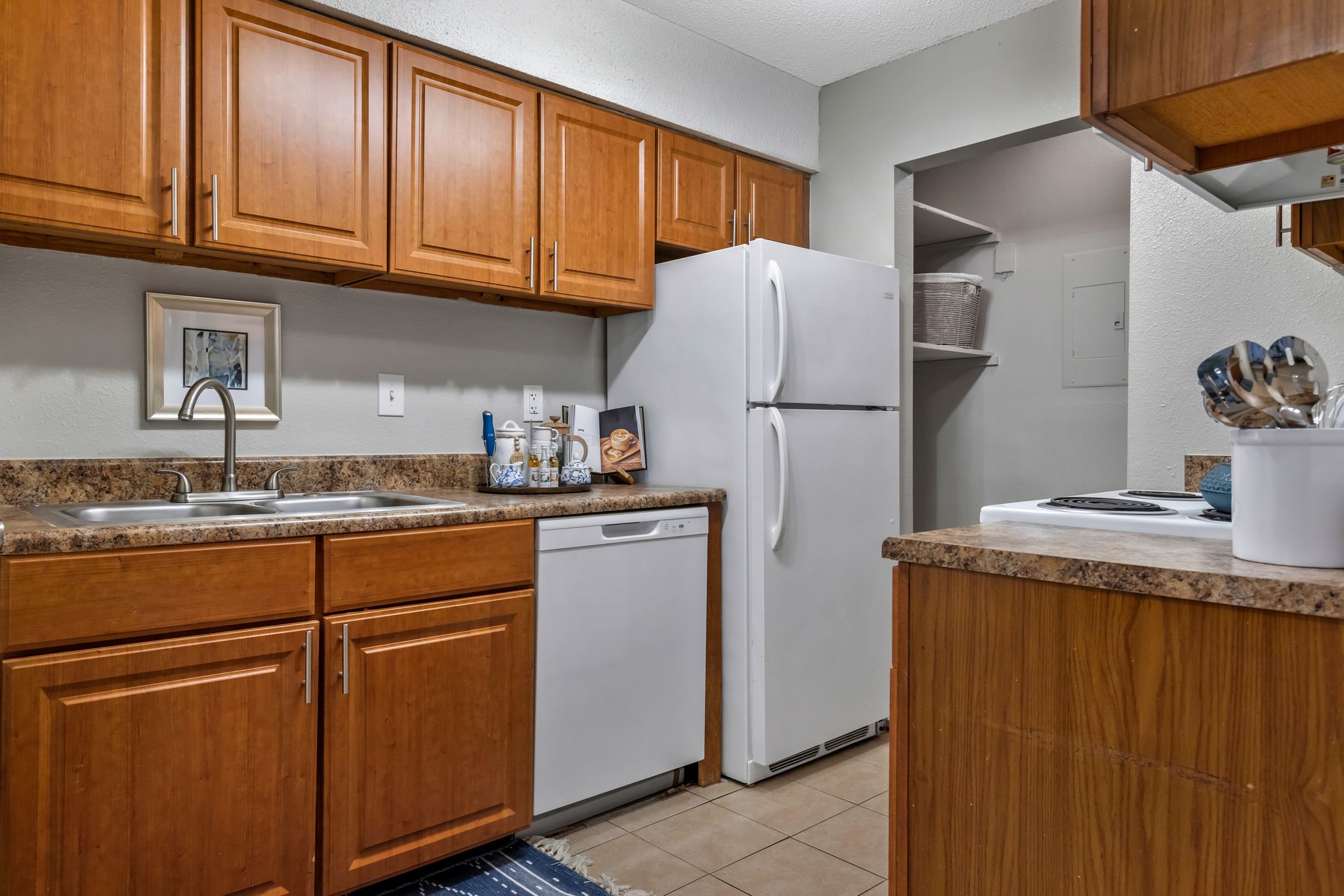 A kitchen with wooden cabinets and a white refrigerator.