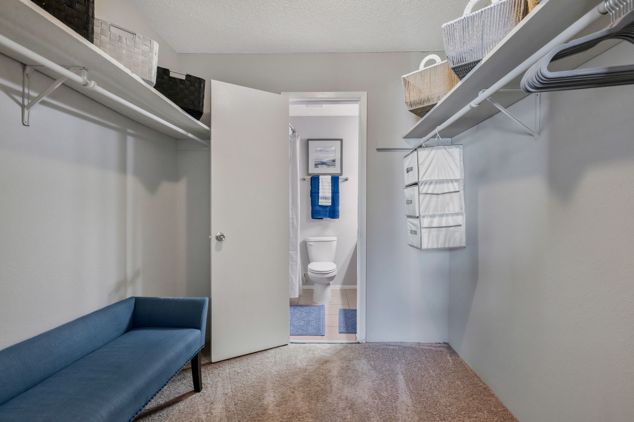 A small room with a blue sofa and a white door.