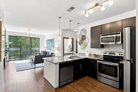 A modern kitchen with a large island and stainless steel appliances.