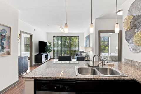 A modern kitchen with a granite countertop and a sink.