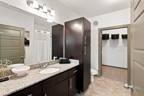 A bathroom with a sink, mirror, and toilet.