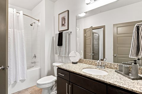 A bathroom with a toilet, sink, and shower.