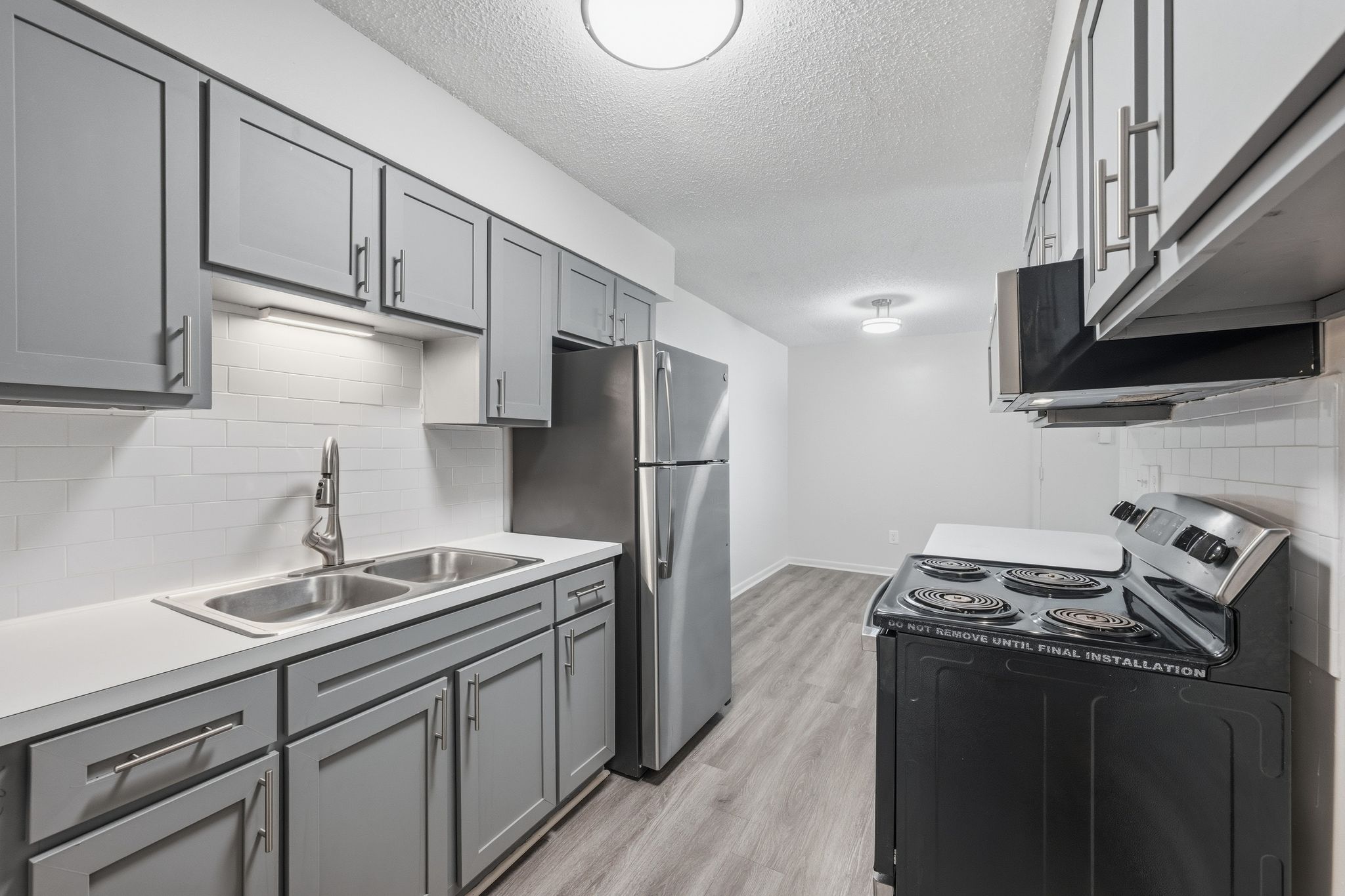 A kitchen with a stove top oven and a refrigerator.
