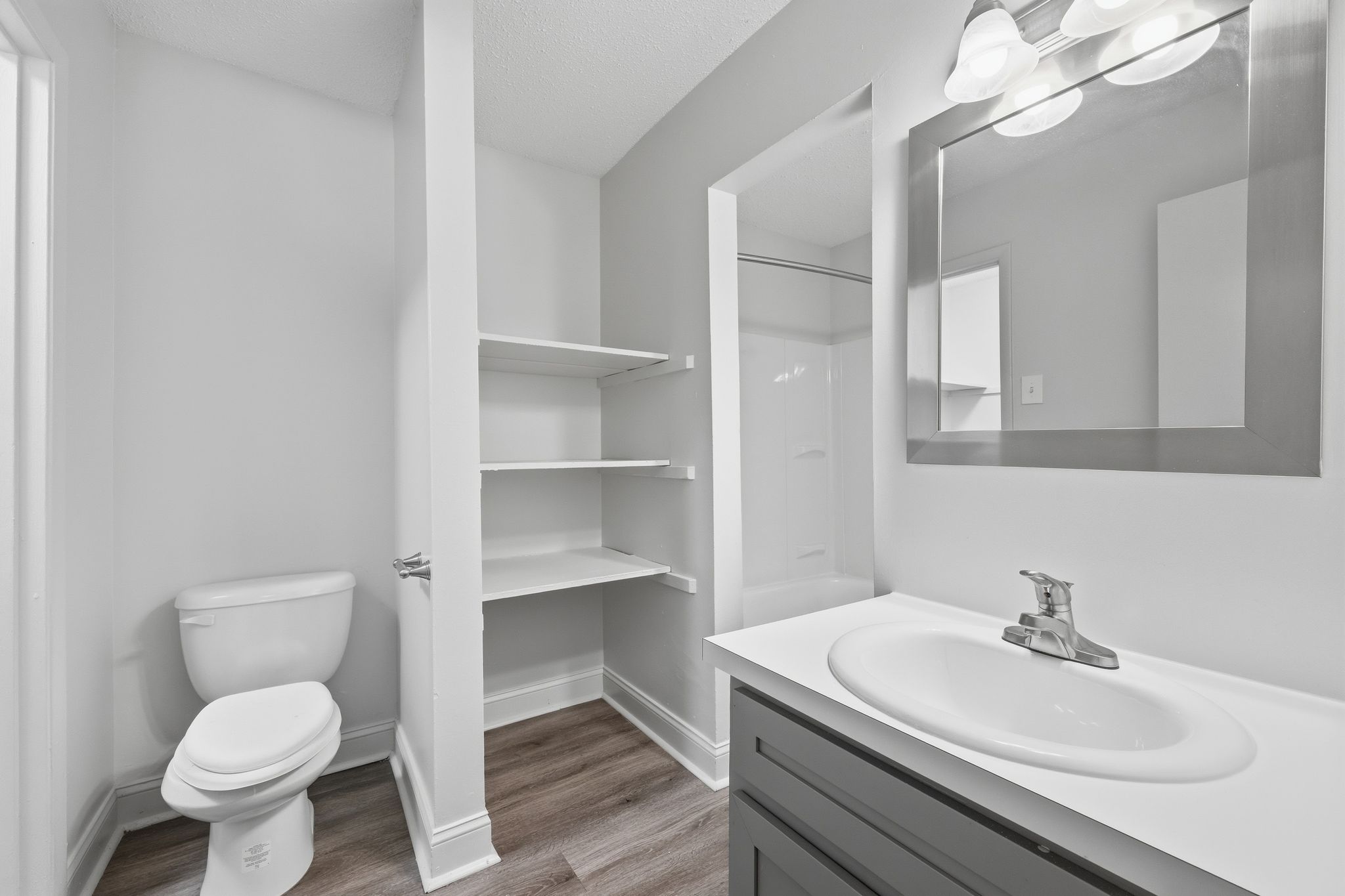 A white toilet sits next to a sink in a small bathroom.