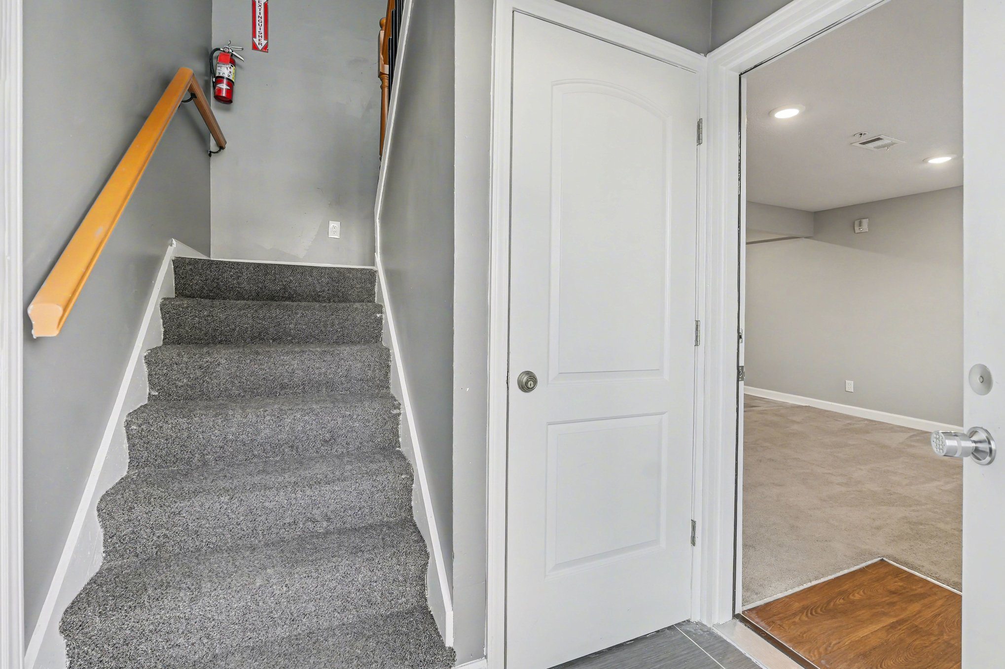 A hallway with a staircase and a door.