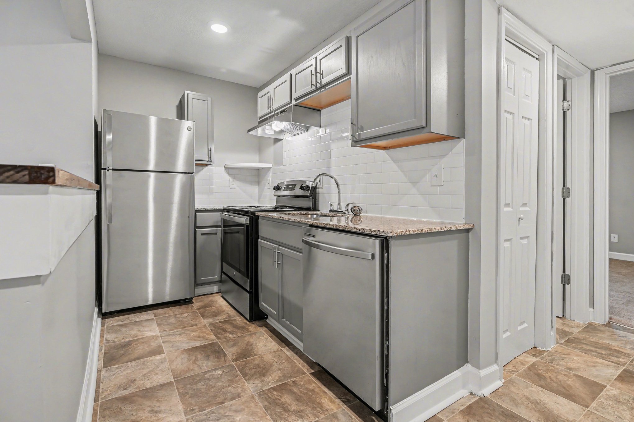 A kitchen with a stainless steel refrigerator and oven.