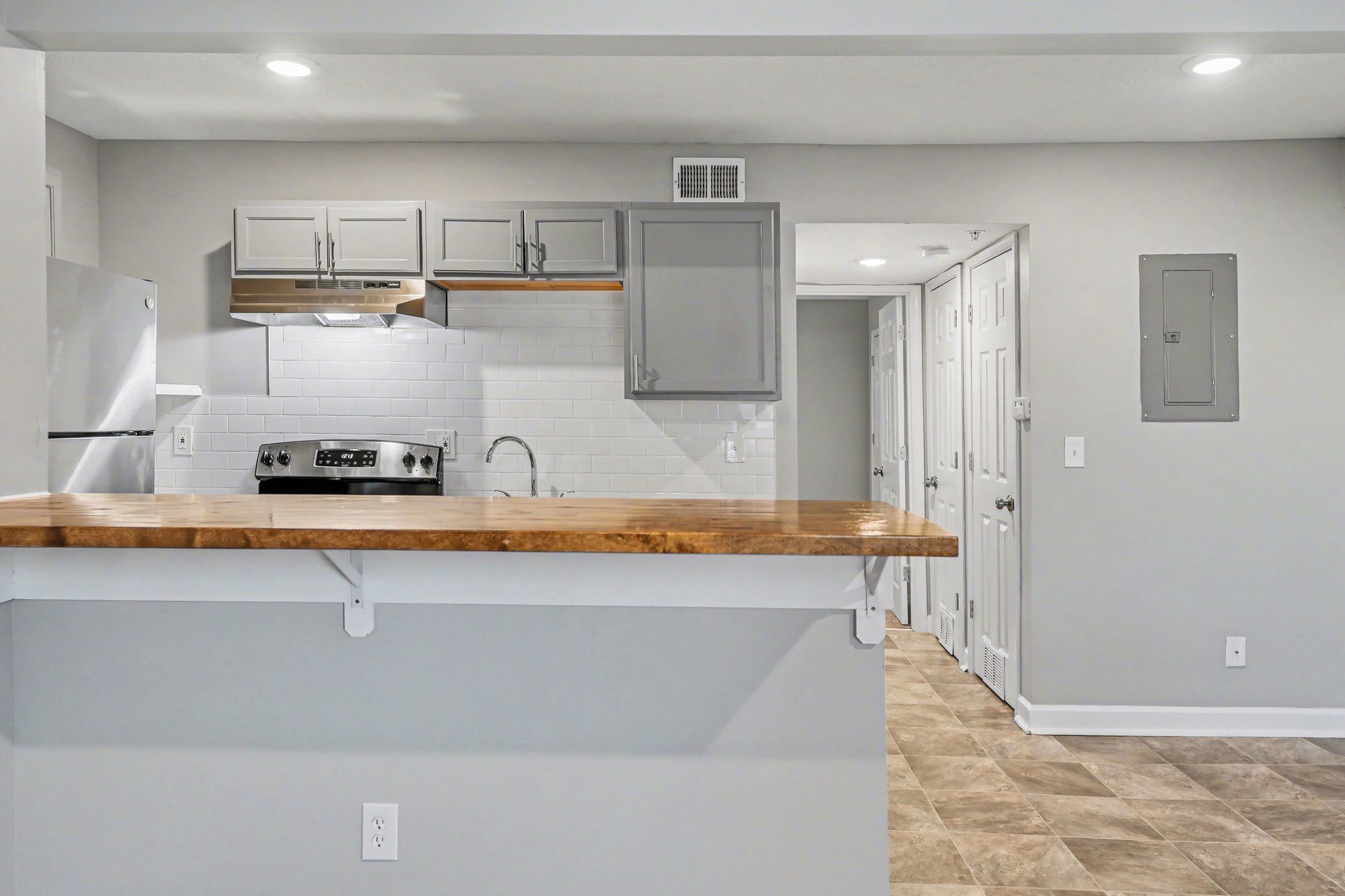 A kitchen with a white refrigerator and a wooden counter top.