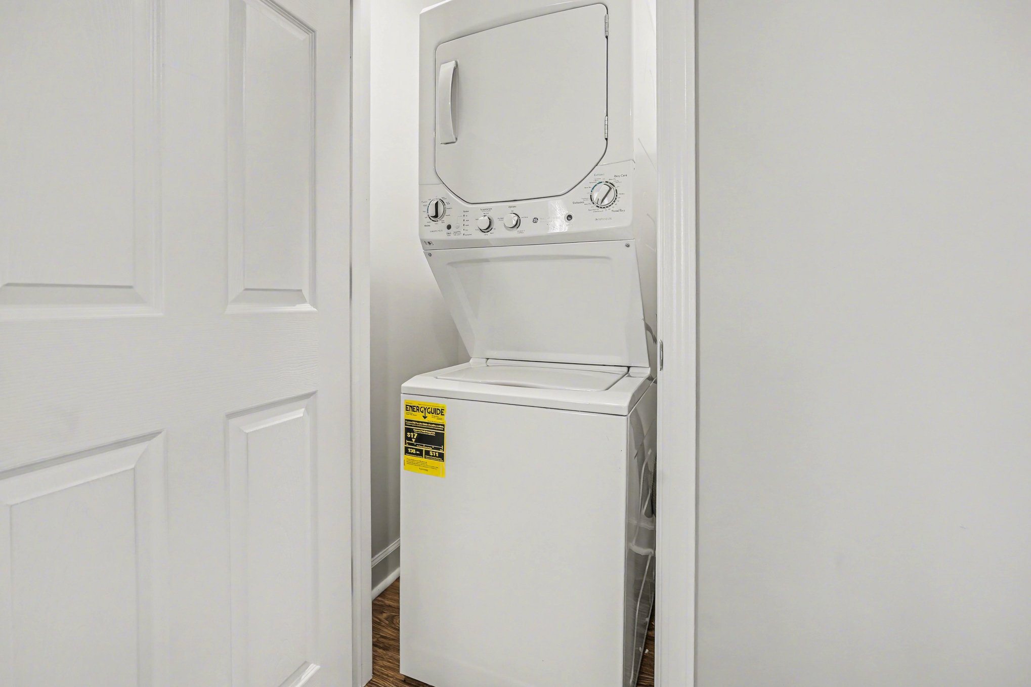 A white washing machine with a yellow sticker on it.
