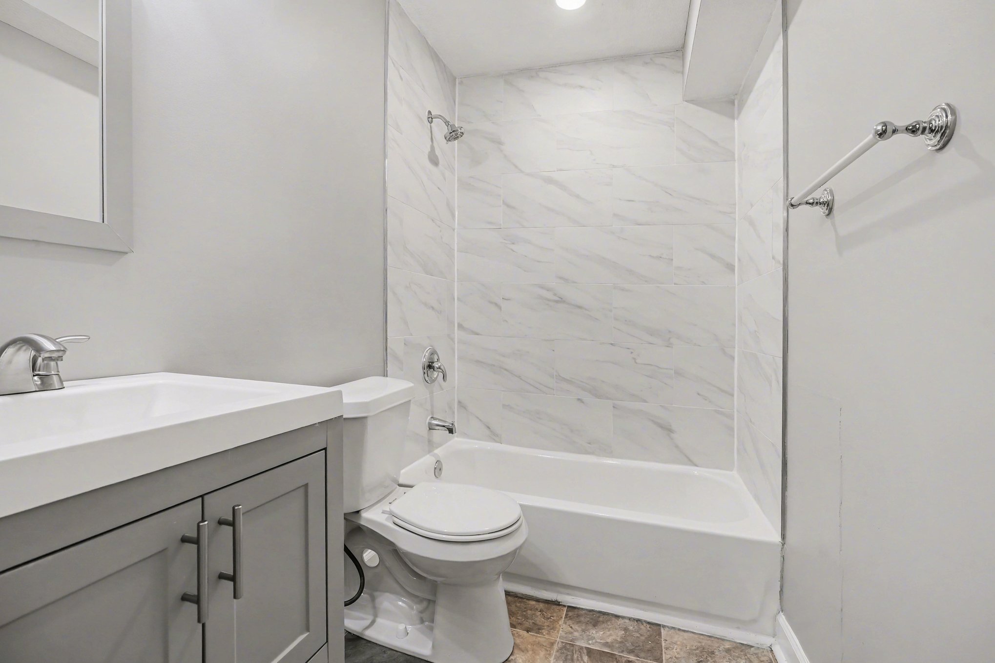 A white bathroom with a toilet, sink, and bathtub.