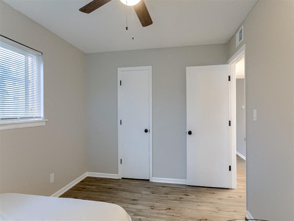 a bedroom with a ceiling fan and a closet