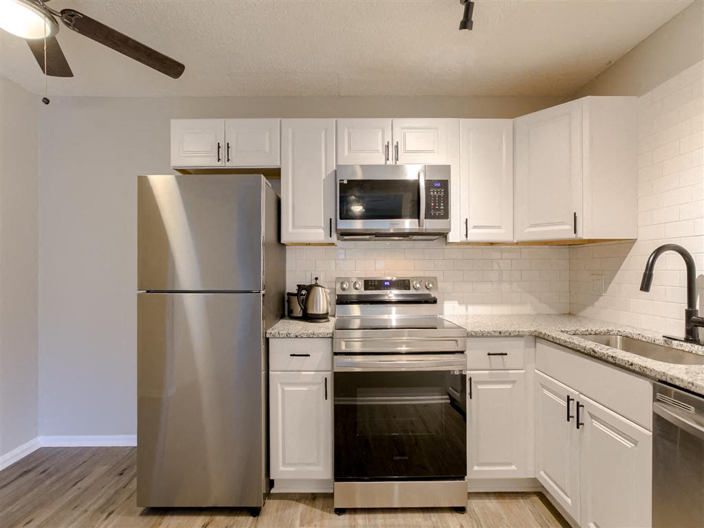 a kitchen with stainless steel appliances and white cabinets
