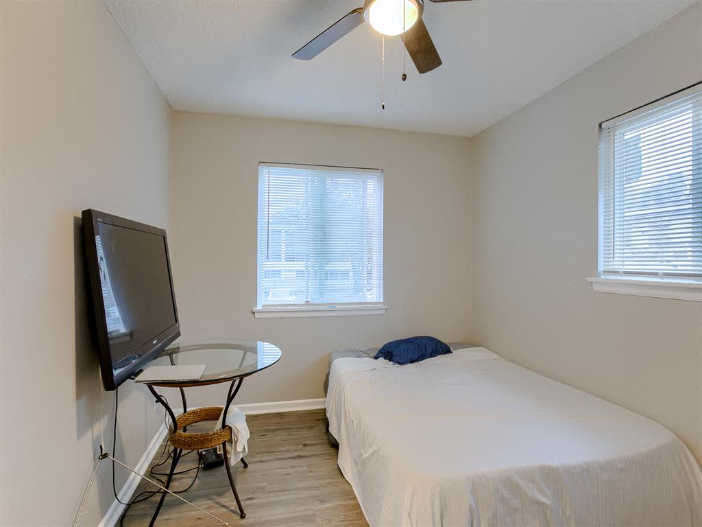 a bedroom with a bed and a ceiling fan