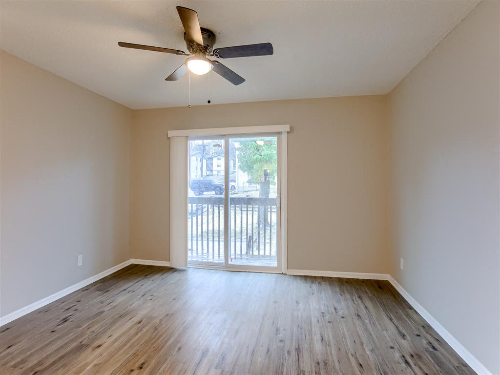 living room view with a ceiling fan and a sliding glass door to the balcony
