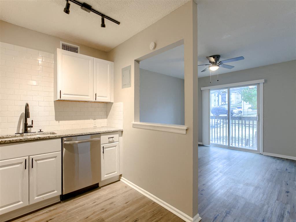 an empty kitchen and living room with a sliding glass door on balcony