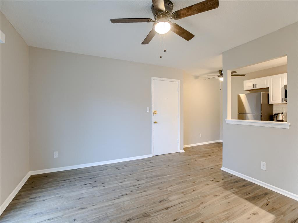 a living room with wood floors and a ceiling fan