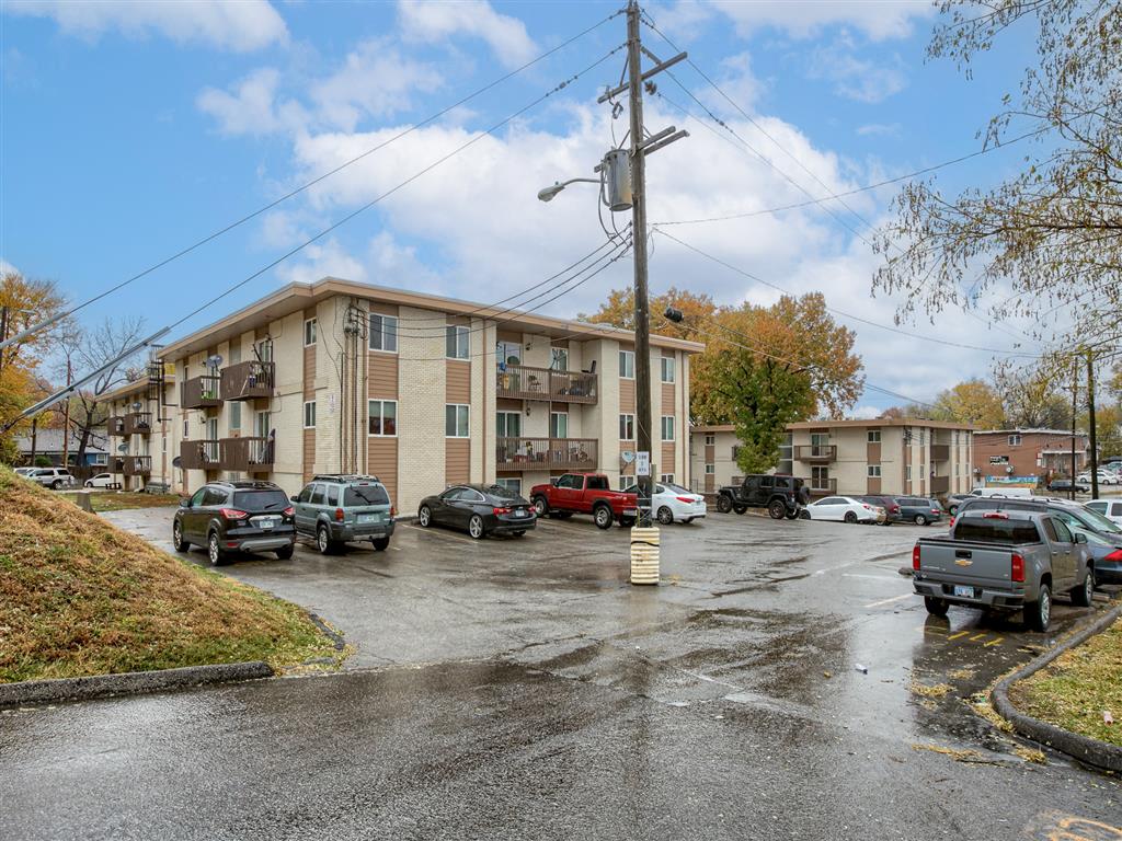 a parking lot with cars in front of an apartment building