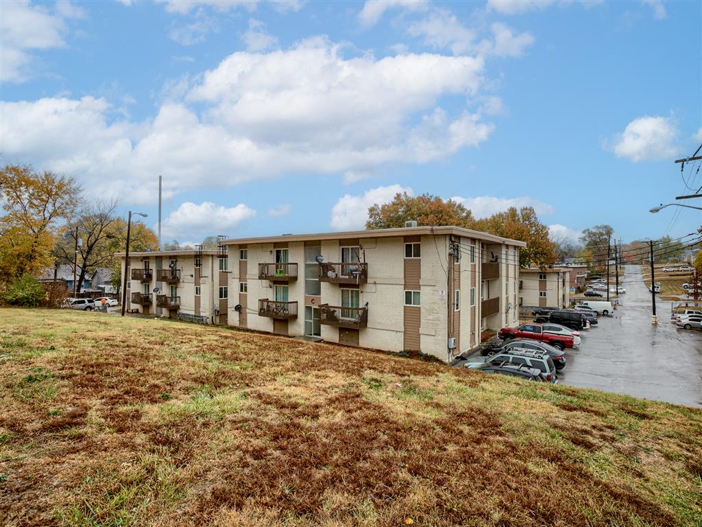 an apartment building on a hill with a parking lot