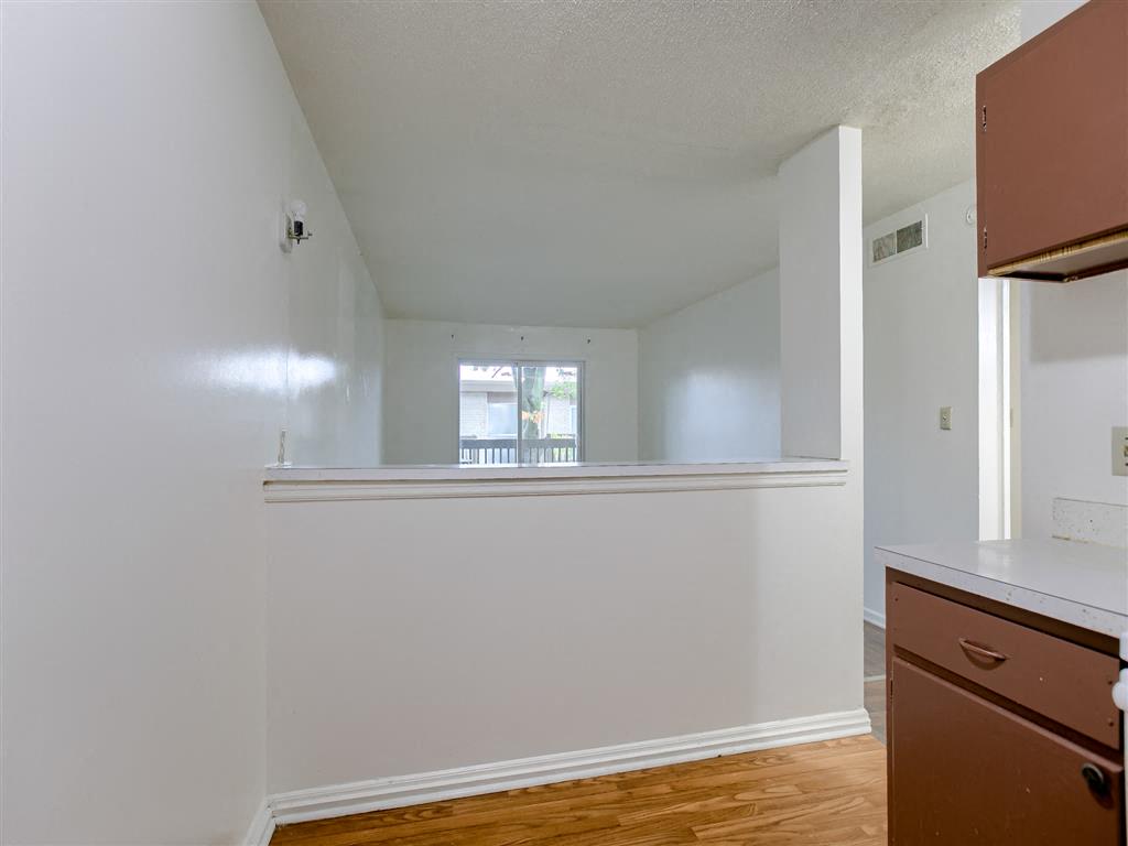 an empty kitchen with a counter top and a window