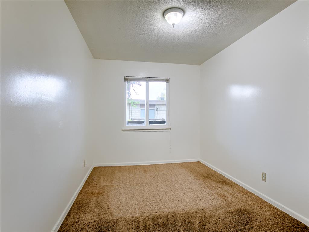 a empty room with a window and carpet