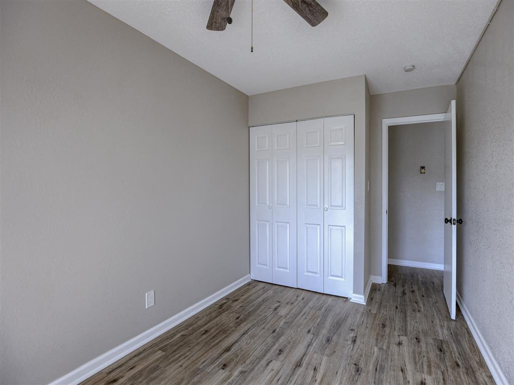 a bedroom with a closet and wood floors