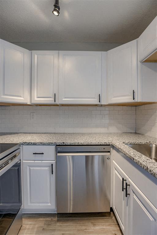 a kitchen with white cabinets and granite countertops