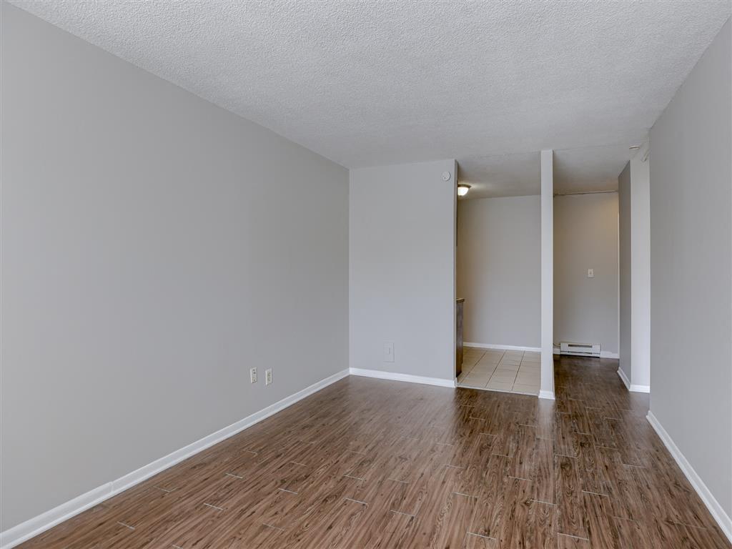 an empty living room with a hard wood floor