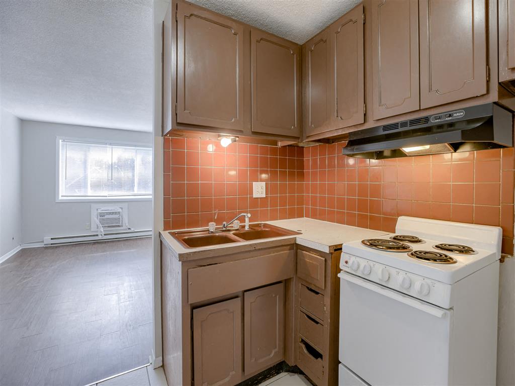 an empty kitchen with a stove and a sink