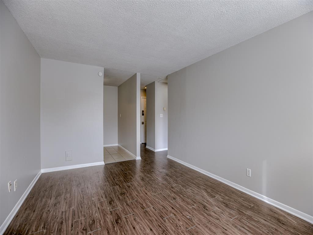 a large empty room with a wood floor and white walls