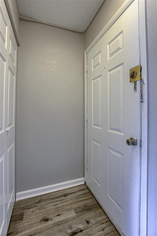 a hallway with a white door and a white closet