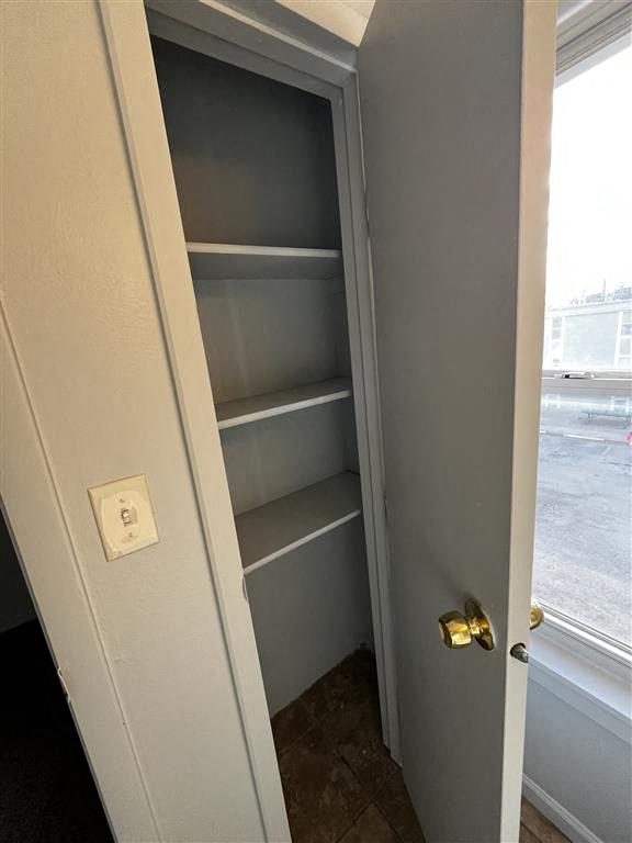 a bathroom linen closet with shelves