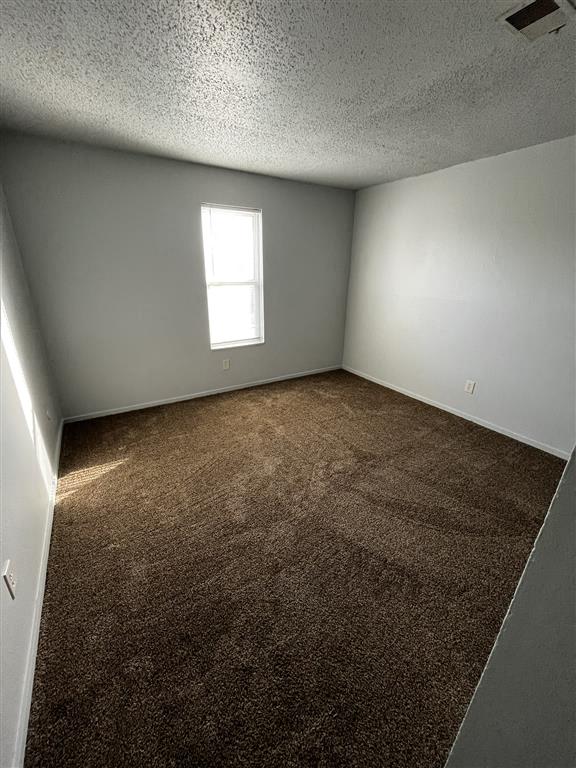 an empty room with carpet and a window