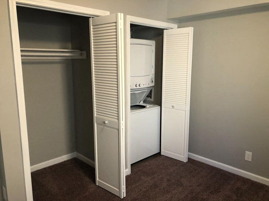 a closet with a stackable washer and dryer