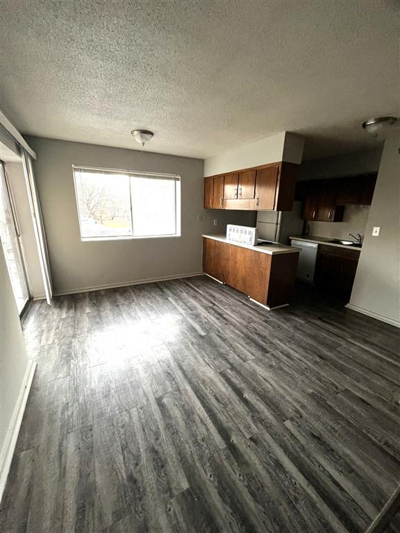 an empty kitchen with wooden floors and a window