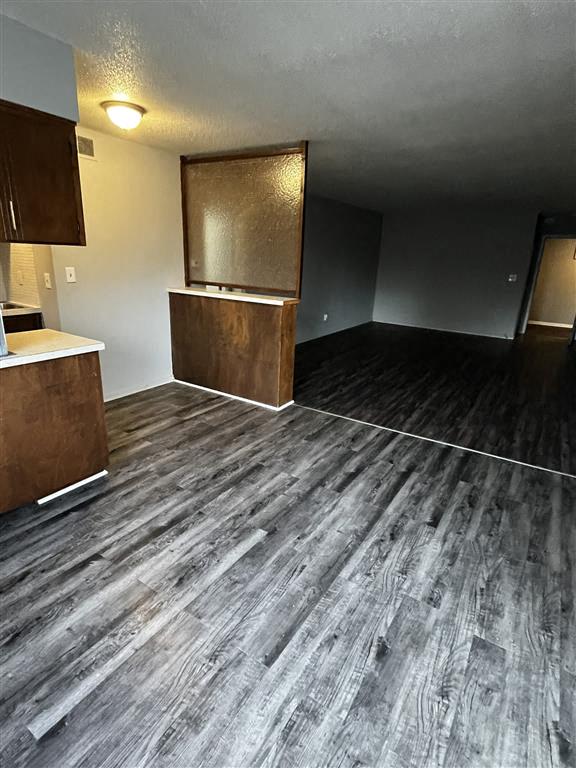 an empty living room with wood floors and cabinets