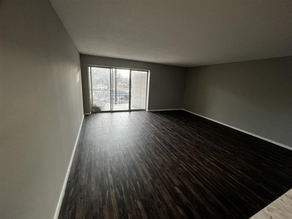 an empty room with a wood floor and a window