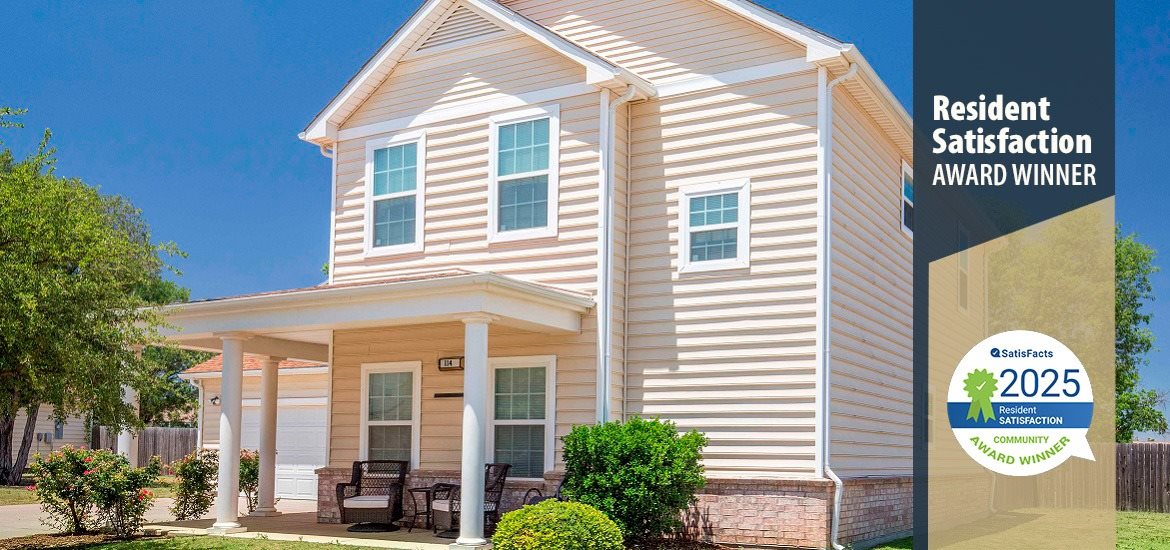 A residential house with a porch and a sign indicating it is a resident satisfaction award winner.