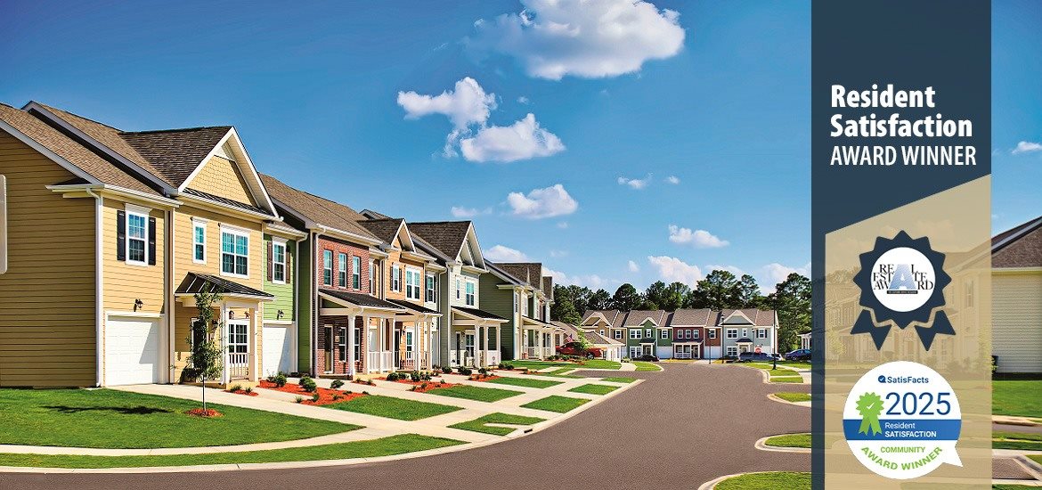A residential neighborhood with houses and a sign that says "Resident Satisfaction Award Winner".