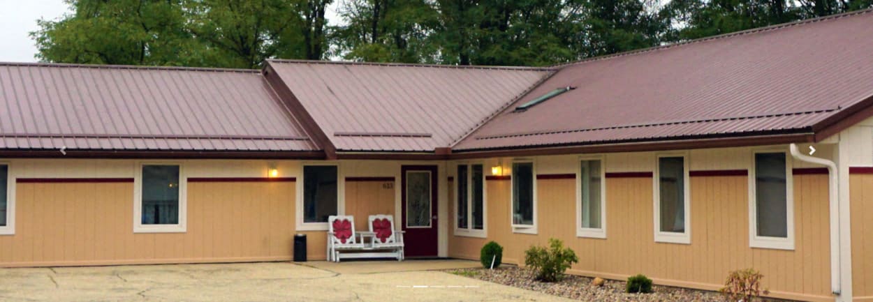 A house with a red roof and beige walls.