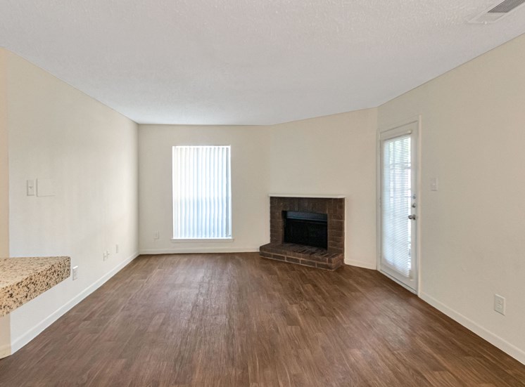 This is a photo of the living room in a 663 square foot 1 bedroom, 1 bathroom with fireplace apartment at The Boulders Apartments in Garland, TX.