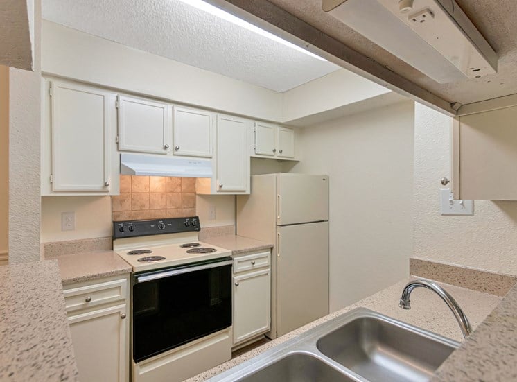 This is a photo of the kitchen in a 663 square foot 1 bedroom, 1 bathroom with fireplace apartment at The Boulders Apartments in Garland, TX.