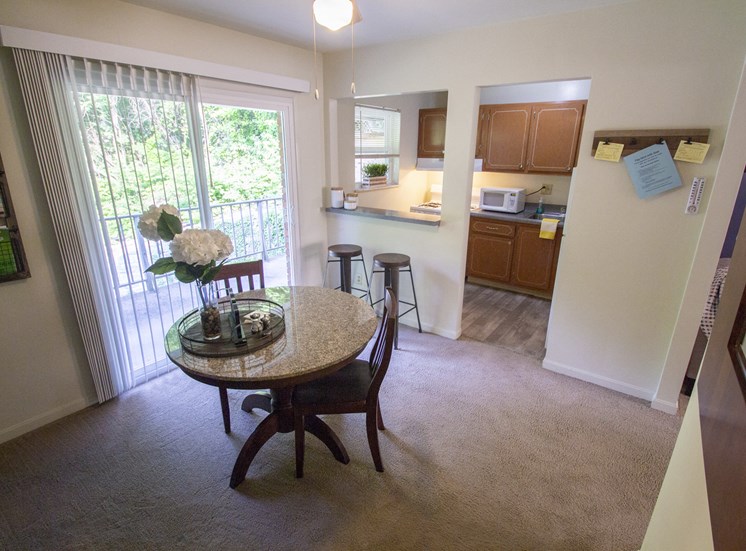 This is a photo of the dining room of the 550 square foot 1 bedroom, balcony floor plan model apartment at College Woods Apartments in Cincinnati, OH.