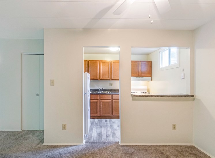 This is a photo of the kitchen from the dining area of the 550 square foot 1 bedroom, balcony floor plan model apartment at College Woods Apartments in Cincinnati, OH.