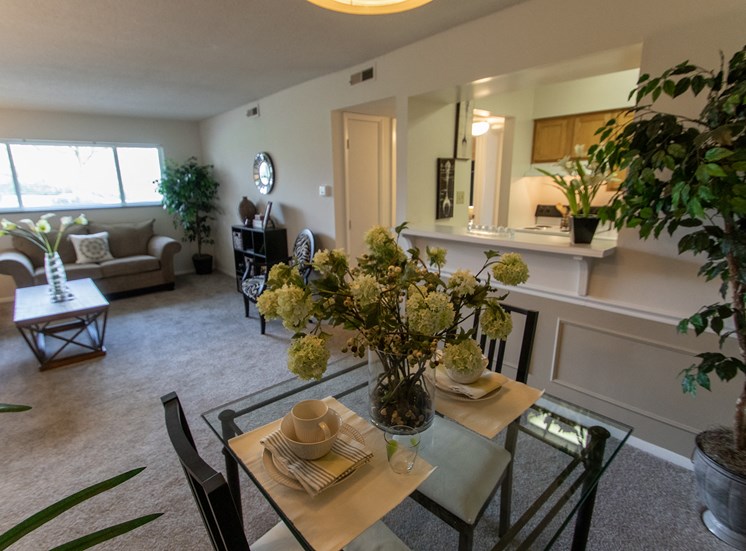 This is a photo of the dining area and living room in the  822 square foot, 2 bedroom floor plan at Village East Apartments in Franklin, OH.