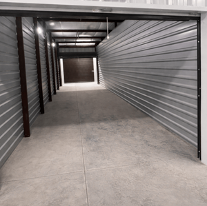 A long, narrow storage unit with a grey floor and walls.