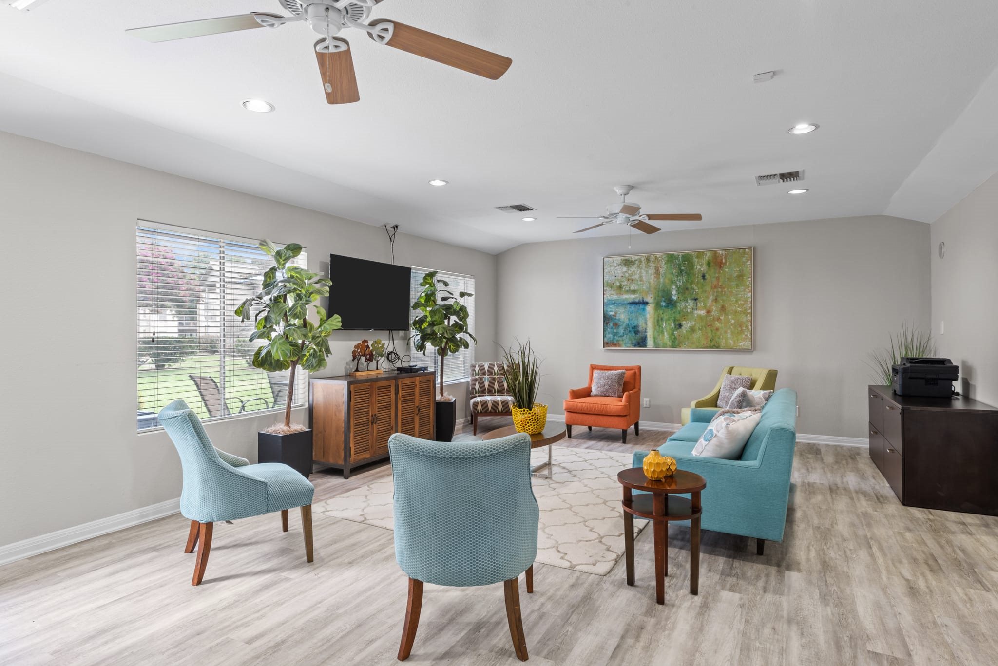 Community lounge with colorful seating and ceiling fans at Peaks at Universal City Apartments, Texas, 78148