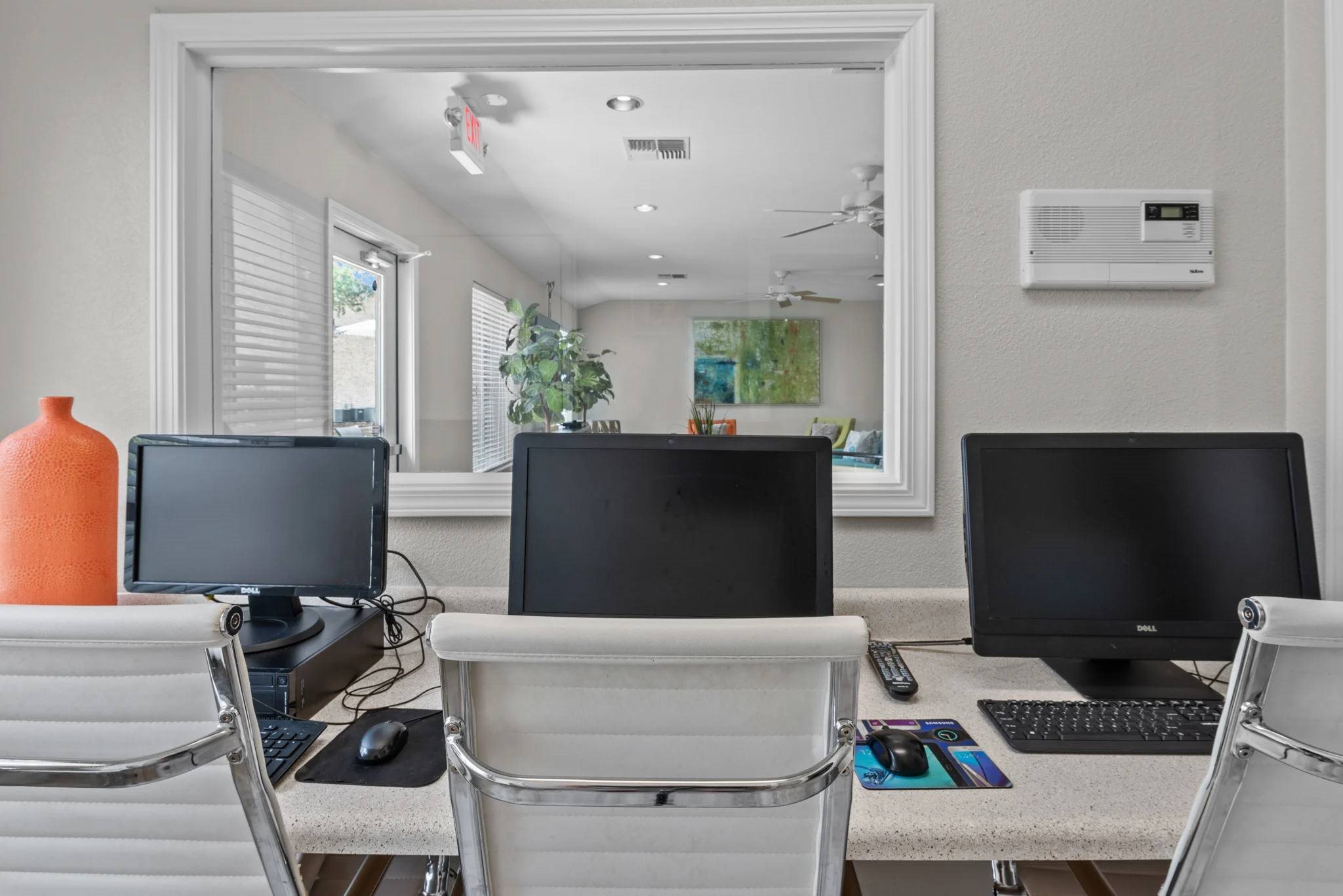 Office workspace with multiple computer stations at Peaks at Universal City Apartments, Texas