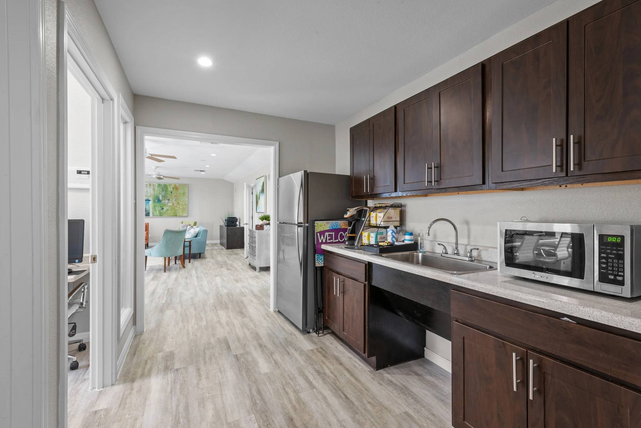 Modern kitchen with stainless steel appliances and dark wood cabinetry at Peaks at Universal City Apartments, Universal City, TX 78148