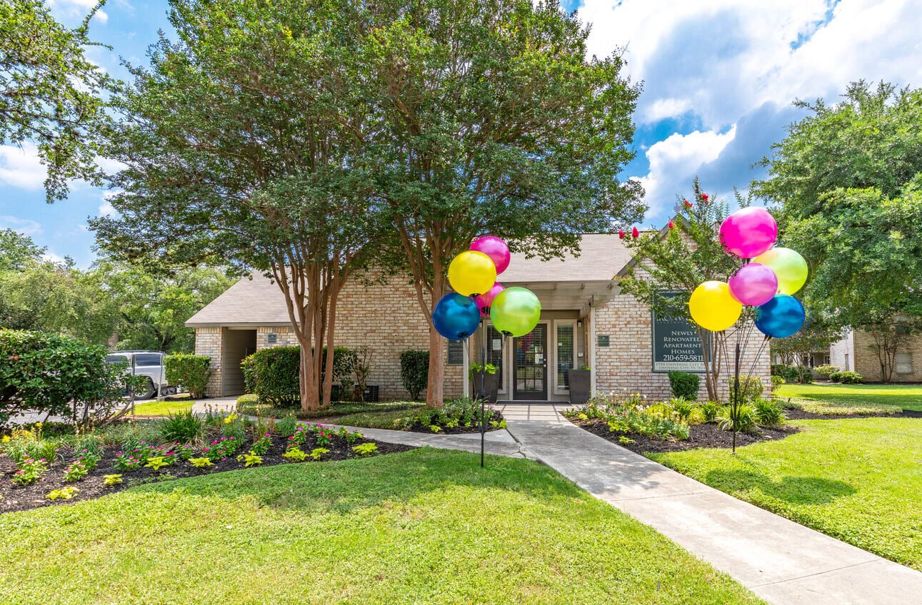 Community leasing office entrance with festive balloon display at Peaks at Universal City Apartments, Universal City, TX 78148