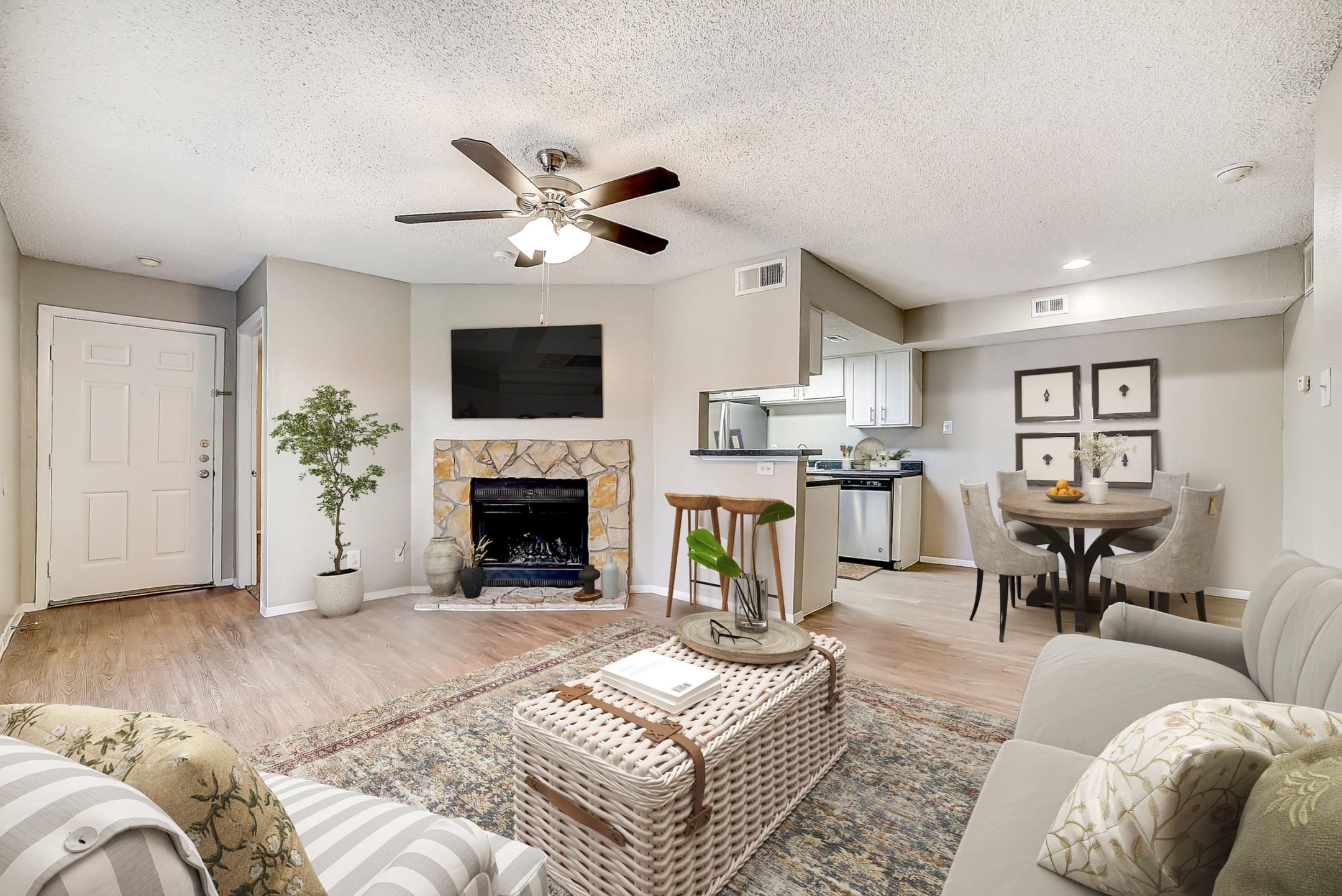 Open concept living room with stone fireplace and kitchen at Peaks at Universal City Apartments, Universal City, 78148