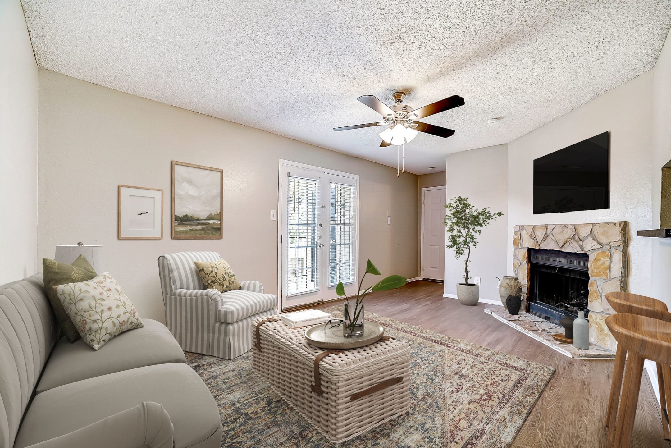 Living room with ceiling fan and stone fireplace at Peaks at Universal City Apartments, Texas, 78148